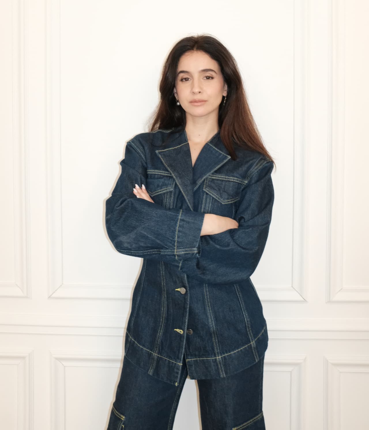 Hourea Alaoui in a denim suit, arms crossed